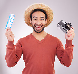 Image showing Ticket, camera and portrait of excited man with paperwork for holiday, adventure and fun hat on white background. Smile, travel and happy person with boarding pass for vacation, journey and happiness