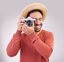 Image showing Travel, camera and happy man on holiday, adventure and fun on white background. Smile, travel and person taking picture, photographer or tourist in studio for summer vacation, journey and happiness.