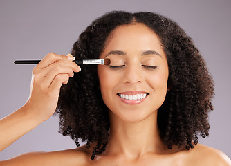 Image showing Woman, beauty and eyeshadow brush in studio for cosmetics, facial skincare and salon transformation. Happy female model makeup application on eyes for aesthetics, happiness and facelift on background