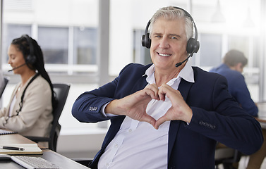 Image showing Portrait, heart hands or mature happy man in call center with smile excited about customer care services in office. Sales, communication or friendly senior consultant with love sign at crm business