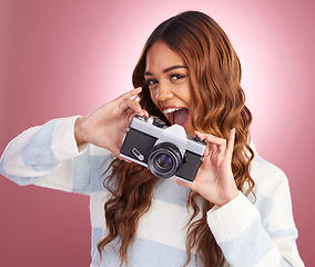 Image showing Portrait, photographer and woman in studio with camera, happy and excited while posing on pink background. Face, person and girl with lens having fun, cheerful and pose for picture or photo