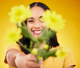 Image showing Happy, portrait and a woman showing flowers isolated on a yellow background in a studio. Floral, spring and a girl giving a bouquet as a present, sharing plants and fresh flower with a smile