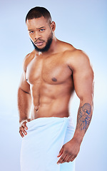 Image showing Portrait, skincare and body with a man on white background and wearing a towel in studio after cleaning. Hygiene, grooming and serious muscular african male model posing shirtless in his bathroom