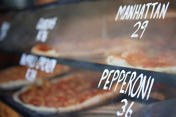 Image showing Storefront, pizza and fast food price, service and take away restaurant with closeup, shop display and window. Words, nutrition at cafe or bakery, lunch or dinner with to go meal option in New York