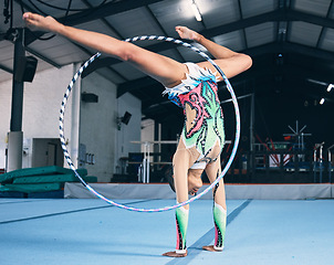 Image showing Sports, gymnastics and woman with a hula hoop for a performance in a professional arena. Fitness, rhythm and female athlete or gymnast doing a flexibility and strength trick training for competition.