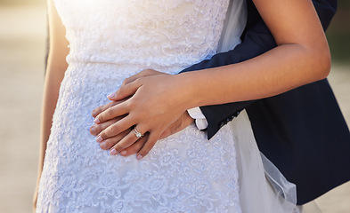 Image showing Wedding, hug and hands of couple with ring for marriage ceremony, commitment and trust outdoors. Love, relationship and man and woman with diamond jewelry for partnership, embrace and celebration