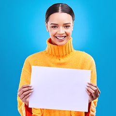 Image showing Happy, mockup and paper with portrait of woman in studio for idea, branding and announcement. Promotion, space and smile with female and sign on blue background for news, logo and advertising