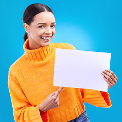 Image showing Pointing, mockup and poster with portrait of woman in studio for idea, branding and announcement. Promotion, space and smile with female and sign on blue background for news, logo and advertising