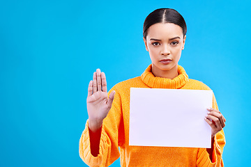 Image showing Serious, stop and woman with a poster in a studio with mockup, copy space and blank space. Confidence, portrait and female model from Brazil with a paper and hand gesture isolated by blue background.