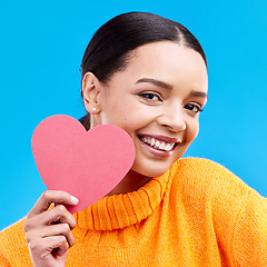 Image showing Paper heart, love and portrait of happy woman in studio, blue background and romantic sign. Female model, emoji shape and smile for care, support and thank you for kindness, valentines day or emotion