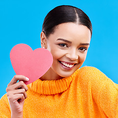 Image showing Paper heart, smile and portrait of woman in studio, blue background and backdrop. Happy female model, love shape and care of trust, support and thank you for kindness, valentines day and emoji icon