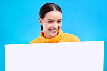 Image showing Happy, mockup and poster with portrait of woman in studio for idea, branding and announcement. Promotion, space and smile with female and sign on blue background for news, logo and advertising