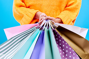 Image showing Shopping bags, studio and woman hands with deal and gifts from boutique sale. Retail, customer and female model with store bag and sales choice in isolated blue background with fashion purchase