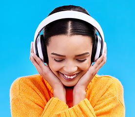 Image showing Music headphones, woman and smile on blue background, studio and color backdrop. Happy female model listening to sound, streaming album and audio connection on media, gen z and hearing radio podcast