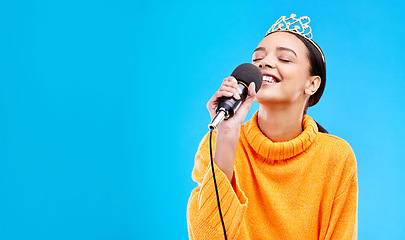 Image showing Singer woman, crown and microphone in studio mockup with smile for singing performance by blue background. Happy gen z girl, model or recording artist mic for karaoke, music and mock up with tiara