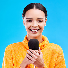 Image showing Happy, microphone and portrait of woman in studio for singing, karaoke and journalist. Reporter, news announcement and media with female on blue background for information, interview or communication