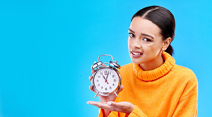 Image showing Woman, alarm clock and annoyed in studio portrait with mockup space by blue background. Gen z girl, student and model with watch for time management, schedule or angry face in mock up by backdrop