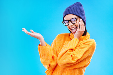 Image showing Woman palm, happiness and portrait in a studio with promotion and announcement. Excited, isolated and blue background with mockup of a gen z girl and cool young female show marketing with smile