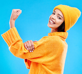 Image showing Happy, arm and portrait of a woman with muscle isolated on a blue background in a studio. Smile, strong and a girl showing muscles, power and motivation for exercise on a backdrop for confidence