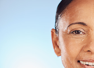 Image showing Portrait, mockup and woman wet, closeup and skincare against blue studio background. Face, senior female or person with liquid, cleaning or washing for hygiene, grooming or morning routine for beauty