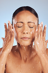 Image showing Old woman, cleaning face and water, beauty and sustainable skincare with antiaging on blue background. Hands, healthy skin and eco friendly dermatology, natural cosmetics and female in studio