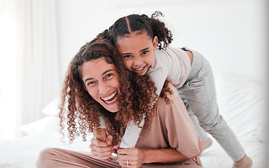 Image showing Portrait, mother and girl on bed, piggy back and smile with joy, bonding and quality time. Face, mama carry daughter or happiness in bedroom, loving or interracial with female child, kid or mom relax