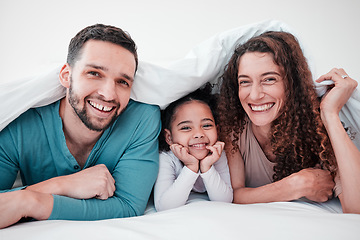 Image showing Family in bed, happy parents and child in portrait, relax and smile together with love and care. Spending quality time under blanket, bonding and relationship, man and woman with young girl at home