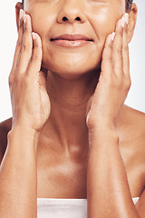 Image showing Hands, mouth and skincare with a senior woman in studio for beauty, anti aging treatment or cosmetics. Skin, facial and wellness with a mature female rubbing her soft face for hydration closeup