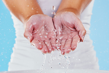 Image showing Water, washing and splash with hands of woman in studio for beauty, sustainability and skincare. Shower, cleaning and cosmetics with female in blue background for self care, spa and disinfection