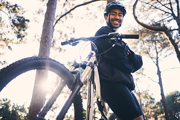 Image showing Forest, fitness and portrait of cyclist with bicycle in nature with smile, adventure trail and health from below. Cycling, woods and man with mountain bike in trees for workout, motivation or energy.