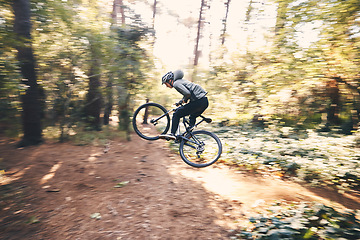 Image showing Cycling, speed and man on a bicycle on a forest road doing training and exercise on a bike. Fast, outdoor trail and athlete on a drive with energy on a nature adventure with fitness on a path