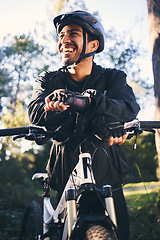 Image showing Forest, fitness and smile, cyclist on bicycle in nature with helmet, exercise adventure trail and healthy mindset. Cycling, relax and man with mountain bike in trees for workout, motivation or energy