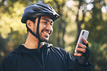 Image showing Man, cycling and outdoor with a phone for communication in nature for sports, exercise or training app. Athlete male person with helmet and smile for fitness workout with smartphone for travel or gps