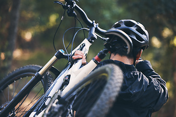 Image showing Forest, fitness and man carrying bicycle in nature with helmet, exercise adventure trail and healthy mindset. Cycling, woods and cyclist with mountain bike in trees for workout, motivation or energy.