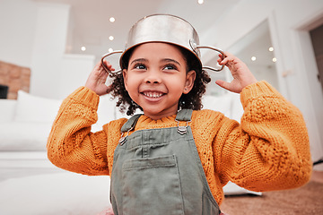 Image showing Children, playing and a girl with a pot on her head in the living room of her home while having fun in a fantasy game. Kids, cute and imagination with an adorable little female child in a house