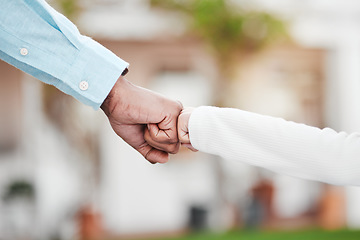 Image showing Adult, child and hands in fist bump for trust, agreement or partnership in generations against a blurred background. Big and small hand bumping fists for support, collaboration or teamwork and growth