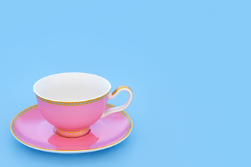 Image showing Pink and Gold Porcelain Tea Cup on Blue Background