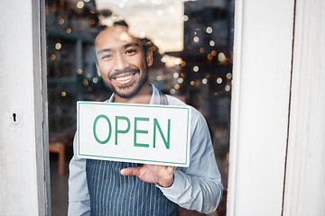 Image showing Asian man, small business and portrait with open sign on window for service in coffee shop or restaurant. Happy male entrepreneur holding billboard, poster or welcome for opening retail store or cafe