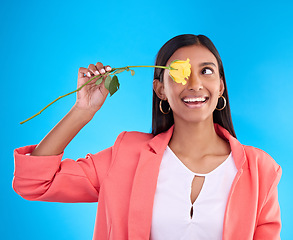 Image showing Rose, love and valentines day with a woman on a blue background in studio thinking about romance. Spring, gift and yellow flower with an attractive young female holding a plant for summer or growth