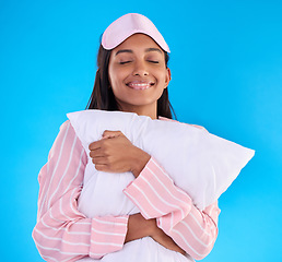 Image showing Sleep, happy and a woman hugging a pillow isolated on a blue background in a studio. Smile, comfy and a girl ready for sleeping, nap or slumber in pyjamas for comfort and coziness on a backdrop