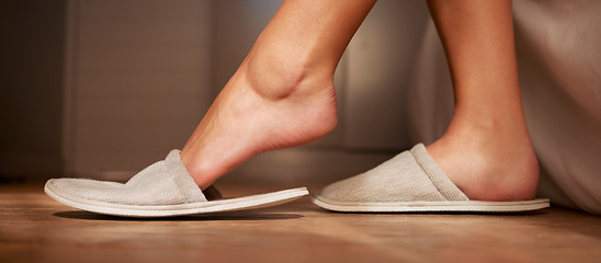 Image showing Feet, slippers and relax with a person in the bedroom of a home during the morning in a hotel on vacation. Luxury, hospitality and holiday with an adult sitting on a bed, enjoying a weekend getaway