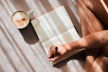 Image showing Notebook, writing and woman hands with coffee for ideas, inspiration and creativity on floor above in sunshine. Creative person with latte for mindfulness, healing notes or self care goals of writer