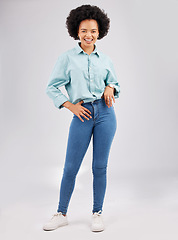 Image showing Fashion, casual and young black woman in a studio with a stylish and trendy outfit with a jeans and shirt. Happy, smile and portrait of an African female model with style isolated by gray background.