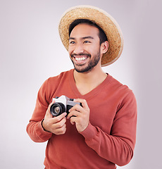 Image showing Travel, camera and happy asian man on holiday, adventure and photography on white background. Smile on face, tourism and Indian photographer or journalist on vacation, happiness on journey in studio.