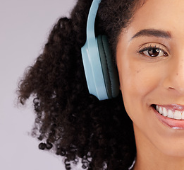 Image showing Headphones, happy woman and portrait of half face, studio background and backdrop. Closeup female model, smile and listening to music, sound and streaming media for audio connection, podcast or radio