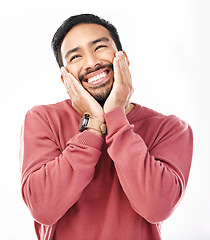 Image showing Face, shy and in love with a man in studio isolated on a white background while touching his cheeks. Thinking, coy and cute with a handsome young indian male feeling special on valentines day