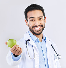 Image showing Doctor, man and apple in portrait, happy with health and nutritionist isolated on studio background. Medical professional, male physician with smile and healthcare, promote healthy diet and nutrition