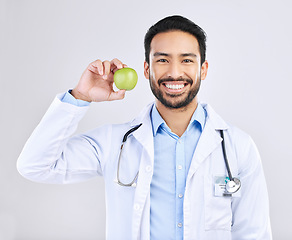 Image showing Doctor, man and apple in portrait with smile, health and nutritionist isolated on studio background. Medical professional, happy male physician and healthcare, promote healthy diet and nutrition