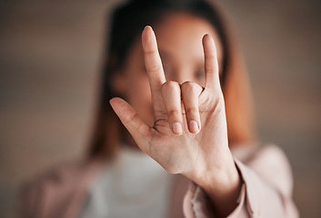 Image showing Hand, sign language and love with a person closeup in studio on a blurred background for communication. Emoji, icon or affection and an adult indoor to gesture romance with a fingers icon signal