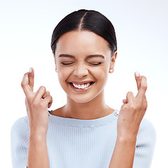 Image showing Fingers crossed, hope and woman with a smile and happiness in a studio with wish. Excited, waiting and hands optimism emoji of a young female ready for winning and lottery prize with white background